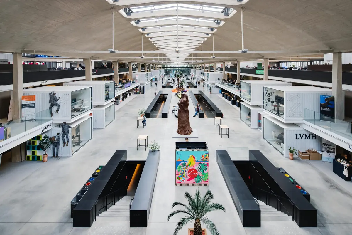The main hall of Station F in Paris, under its long concrete skylight.